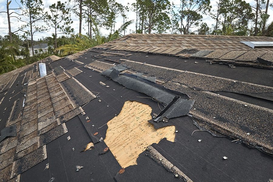 A picture of extensive storm damage to a roof.