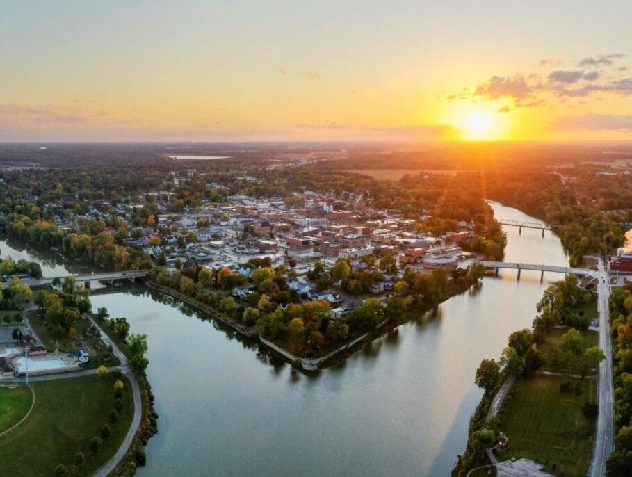 Aerial view of Defiance, Ohio at sunset with Maumee River, bridges, and downtown skyline