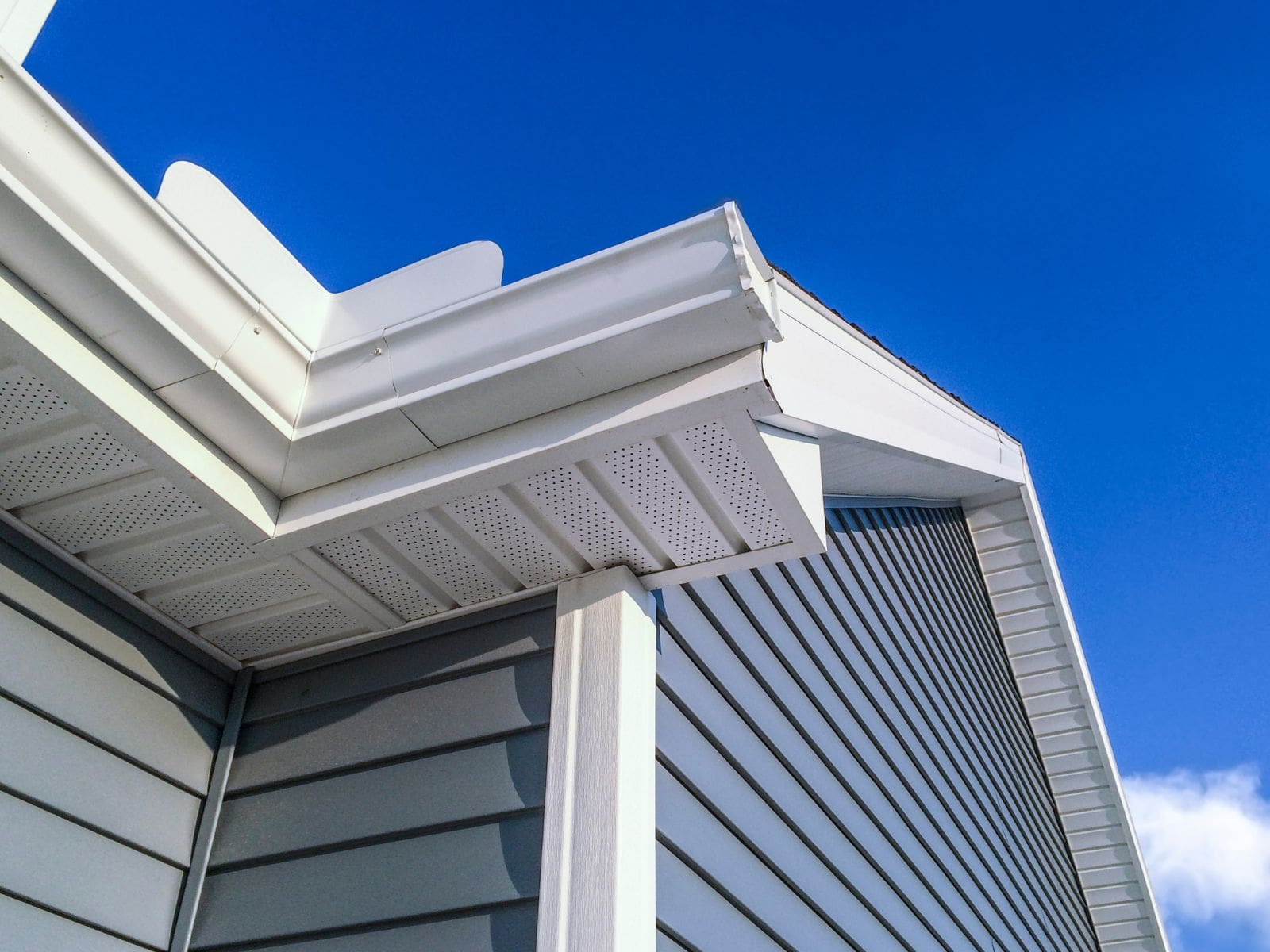 Close-up of residential roofline with vinyl siding, soffit, and seamless gutters installed by Wagner Roofing